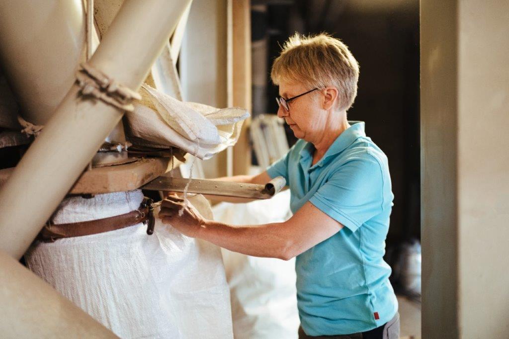 Müllerin Karin Laiber arbeitet an einem Mehlsack. 